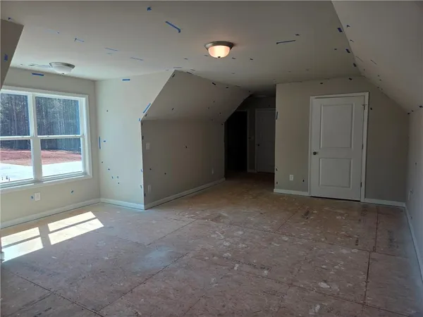 a view of an empty room with a fireplace and a window
