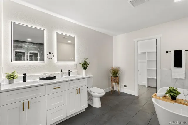 a spacious bathroom with a sink a toilet and a mirror