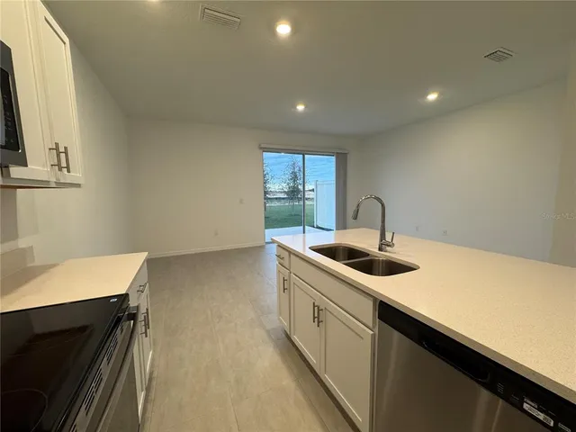 a kitchen with a sink stove and cabinets