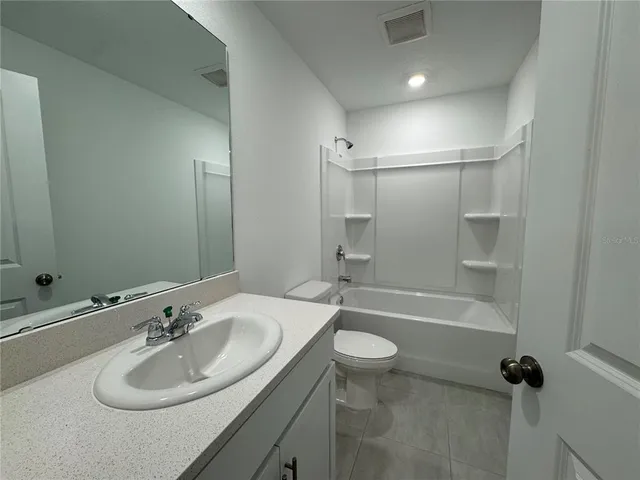 a bathroom with a sink mirror toilet and bathtub