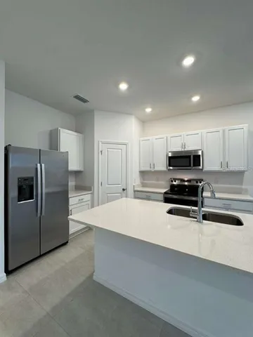 a kitchen with stainless steel appliances a refrigerator sink and microwave
