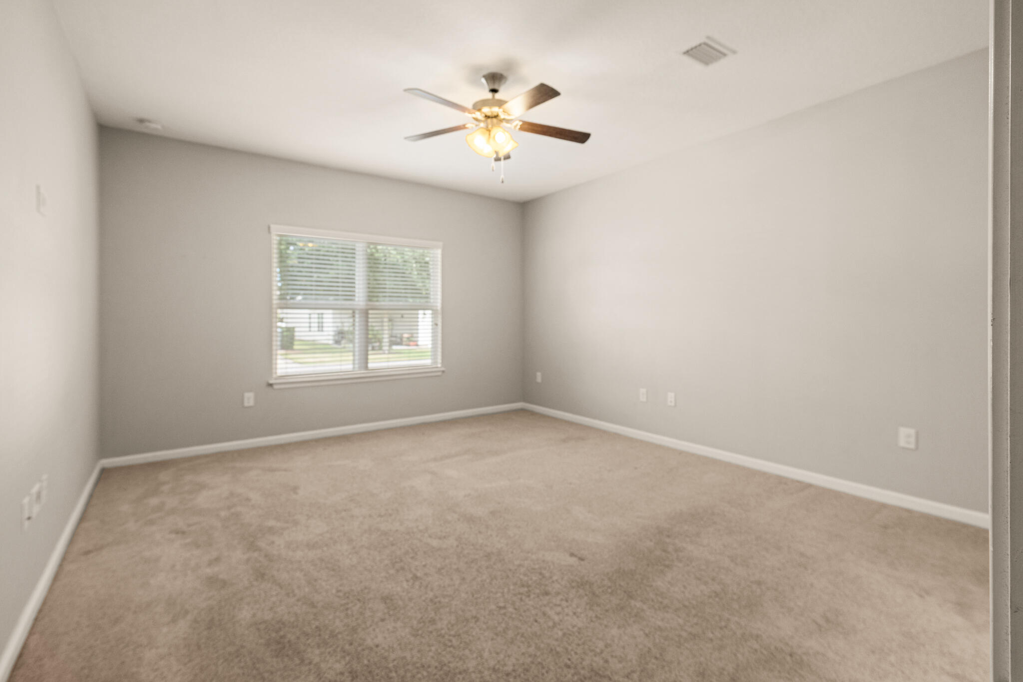 268 Cornelia Street Freeport, FL 32439 - Photo 16 of 41 an empty room with windows and chandelier fan