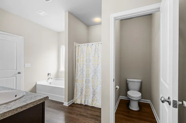 a bathroom with a sink a toilet and shower