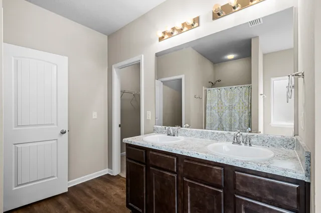 a bathroom with a granite countertop sink and a mirror