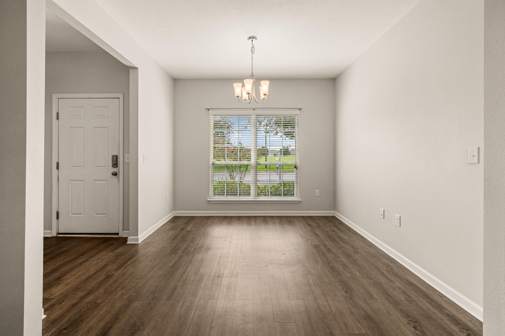 268 Cornelia Street Freeport, FL 32439 - Photo 6 of 41 an empty room with wooden floor chandelier and windows