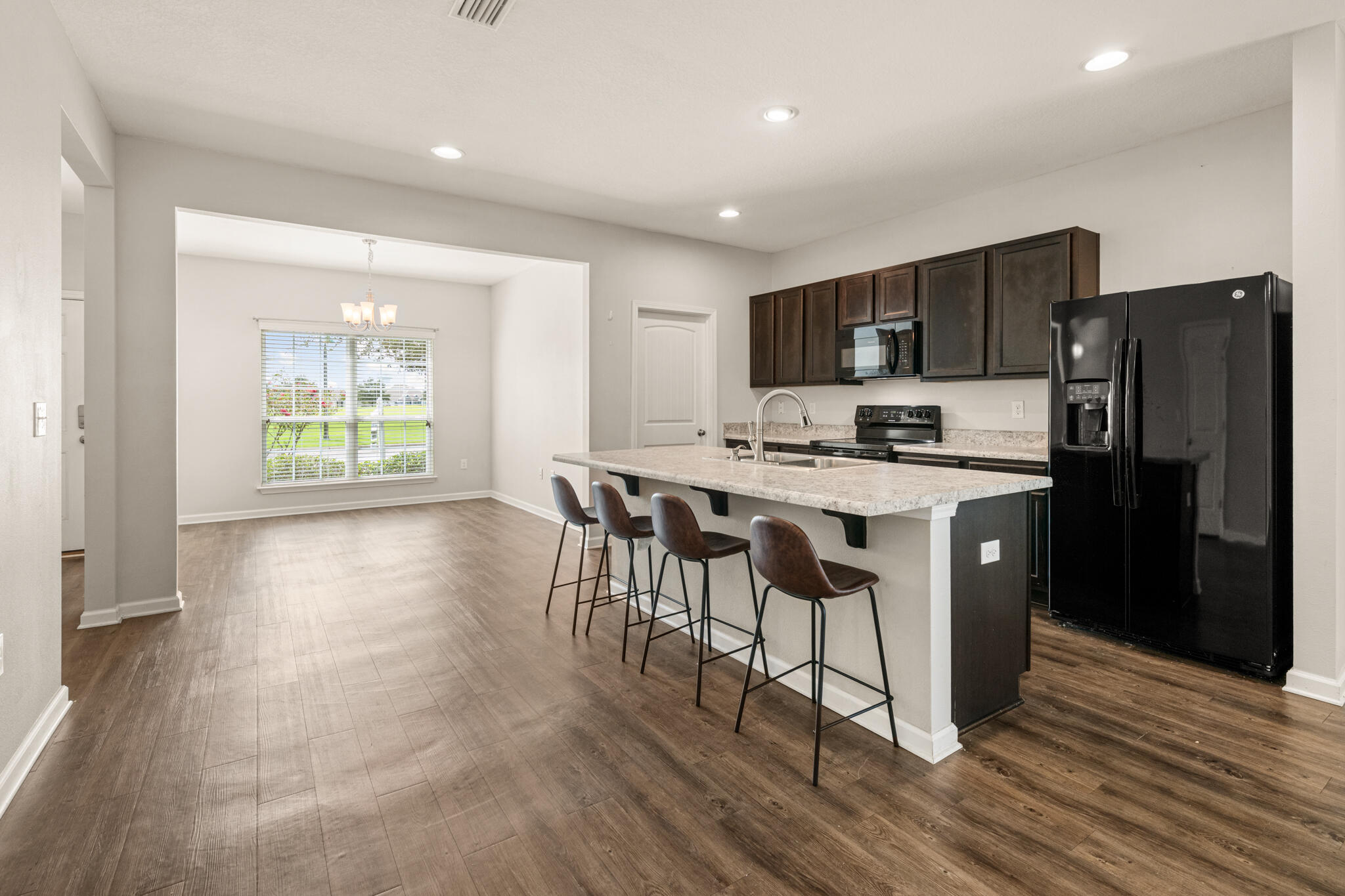 268 Cornelia Street Freeport, FL 32439 - Photo 9 of 41 a kitchen with stainless steel appliances granite countertop a stove a refrigerator a sink a dining table and chairs