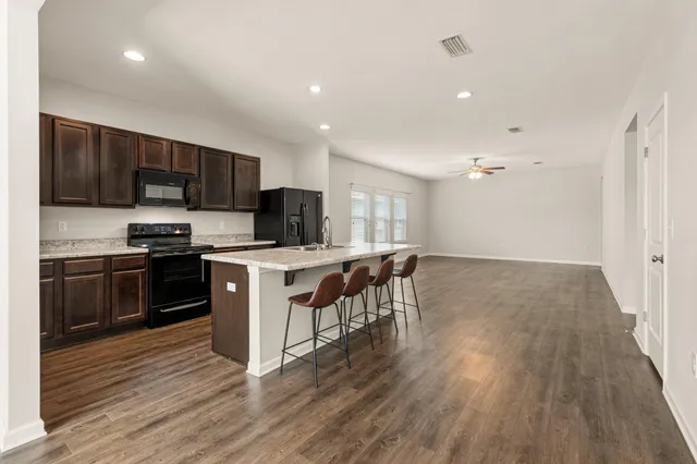 a kitchen with a sink a microwave a stove and cabinets