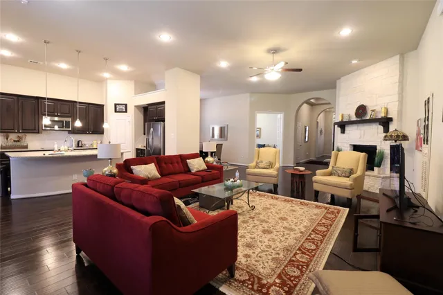 a living room with furniture kitchen and a wooden floor