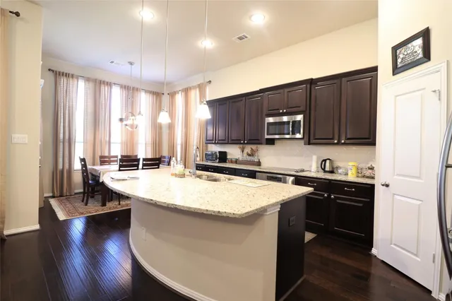 a kitchen with stainless steel appliances granite countertop a sink a stove and a refrigerator