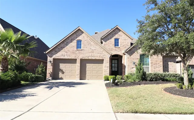 a view of house with yard and tree in front of it