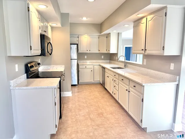 a kitchen with a sink a stove and cabinets