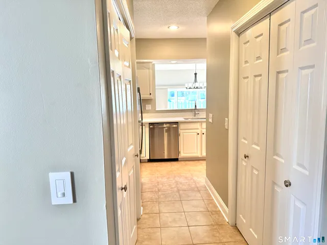 a view of a hallway with wooden floor and a living room