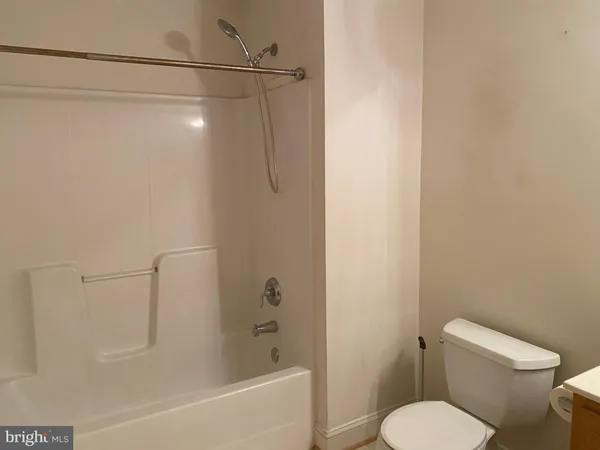 a white toilet sitting next to a bath tub and shower