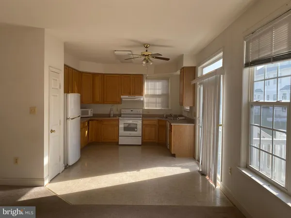 a kitchen with stainless steel appliances a refrigerator a sink a stove and white cabinets