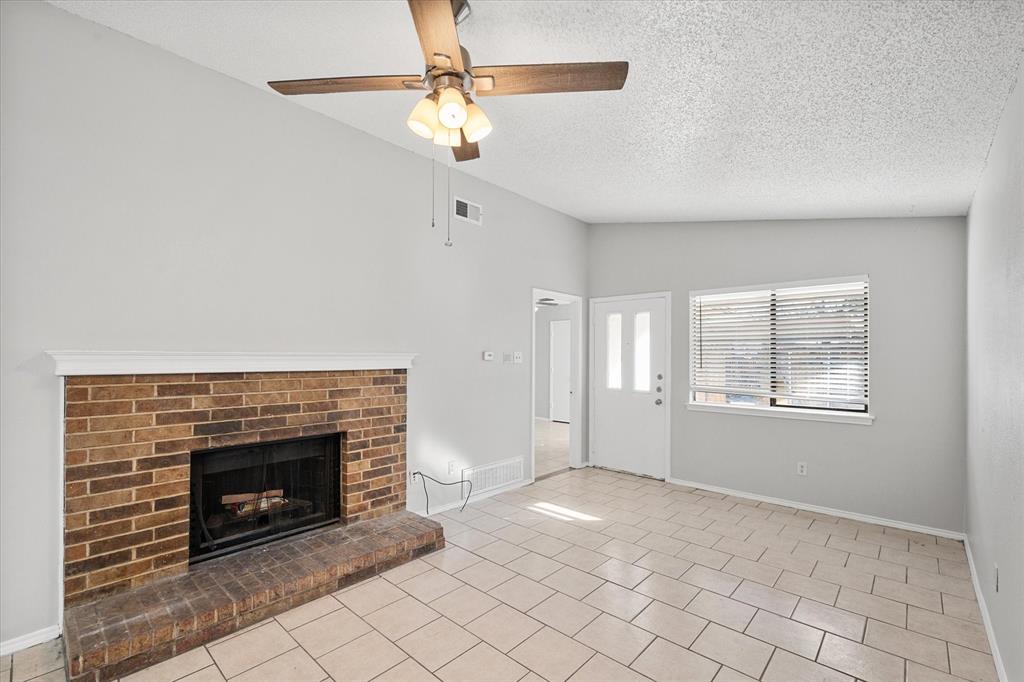 5821 Mansfield Road Arlington, TX 76017 - Photo 12 of 24 an empty room with windows and fireplace
