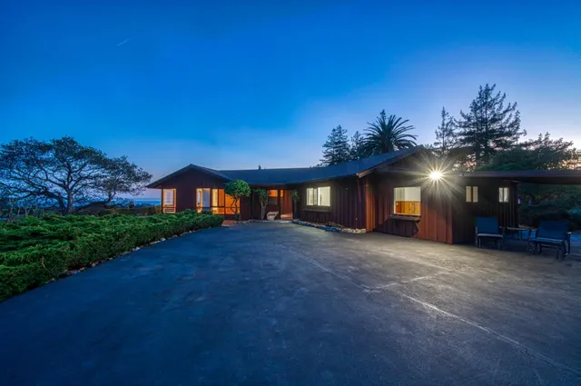 a view of a house with backyard and sitting area