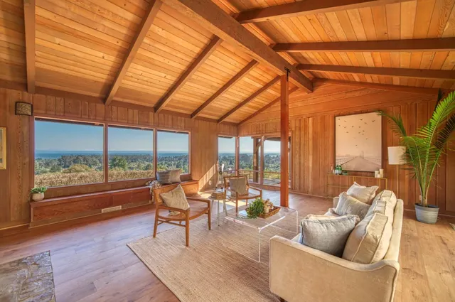 a living room with furniture and a floor to ceiling window