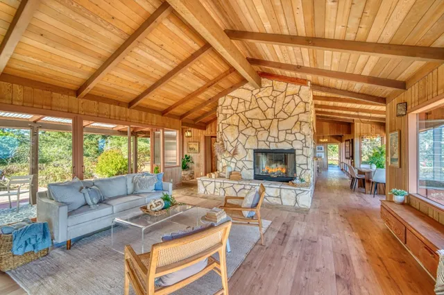 a view of an empty room with wooden floor and furniture