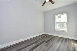 an empty room with a window and a ceiling fan
