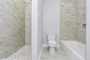 a bathroom with a toilet and a shower