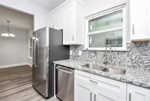 a kitchen with stainless steel appliances granite countertop a sink and a refrigerator