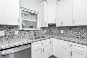 a kitchen with granite countertop a sink and cabinets