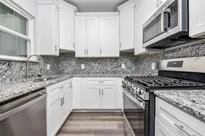 a kitchen with stainless steel appliances granite countertop a sink stove and cabinets