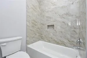 a bathroom with a toilet and a bathtub