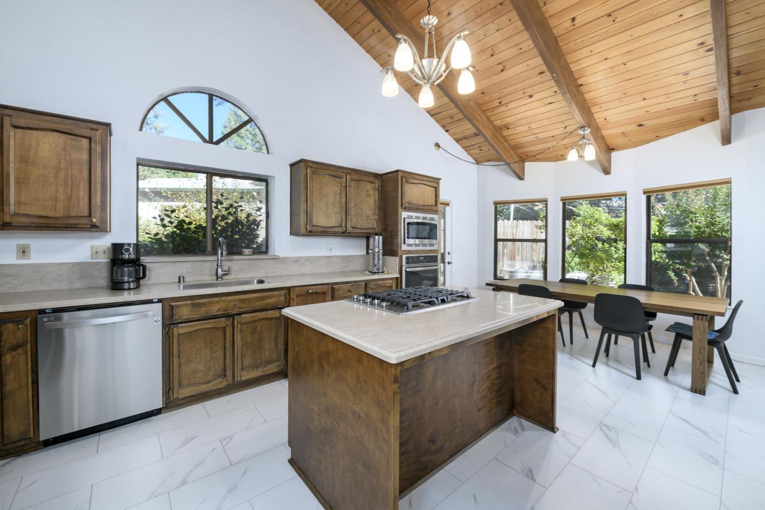 2921 Miller Way Placerville, CA 95667 - Photo 7 of 29 a kitchen with a stove a sink a dining table and chairs