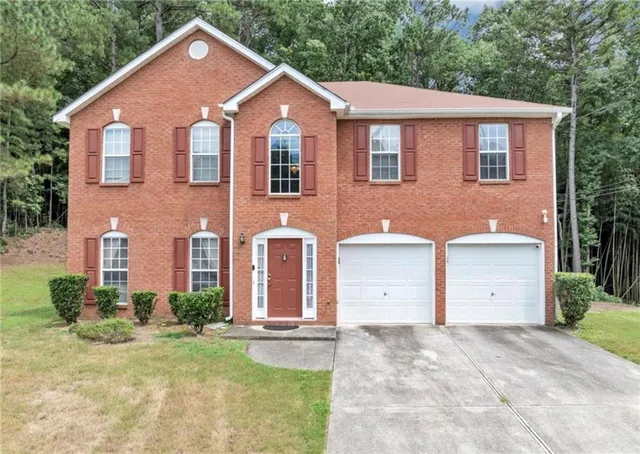 a front view of a house with a yard and garage