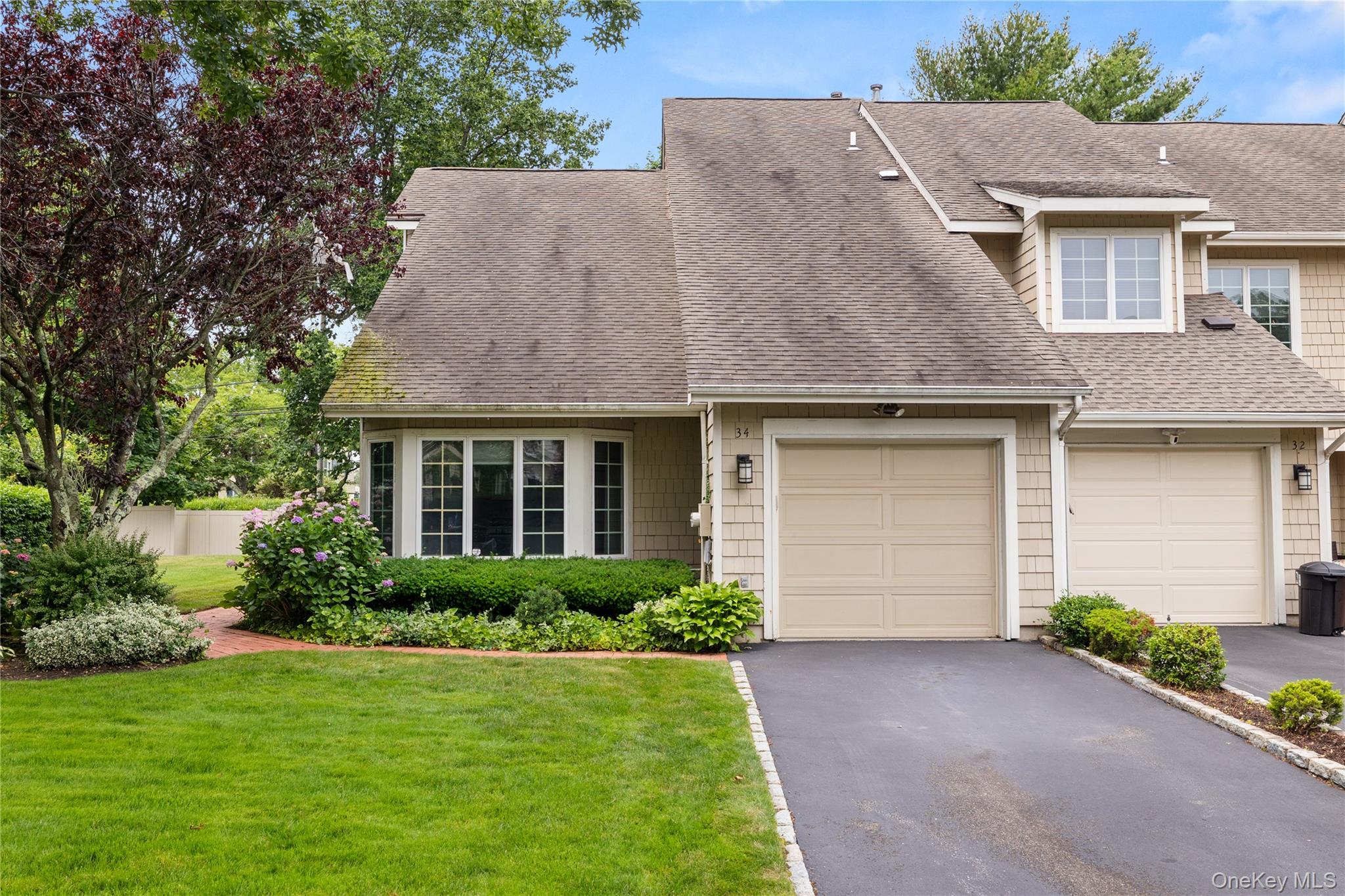 34 Cedar Ridge Lane Bay Shore, NY 11706 - Photo 3 of 27 a front view of a house with a garden and garage