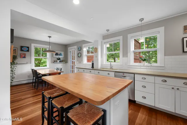 a view of a kitchen that has a table and chairs in it