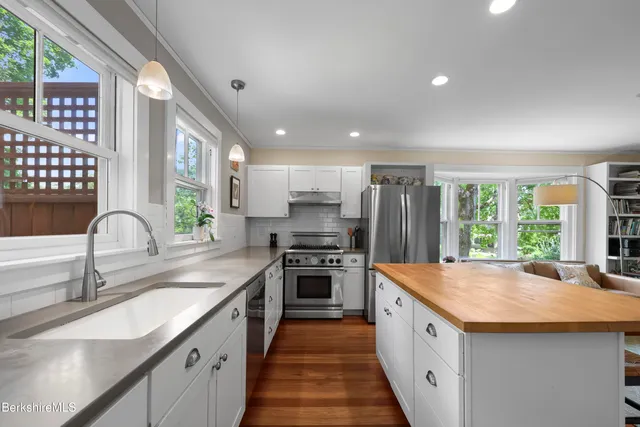 a kitchen with stainless steel appliances granite countertop a sink stove and refrigerator