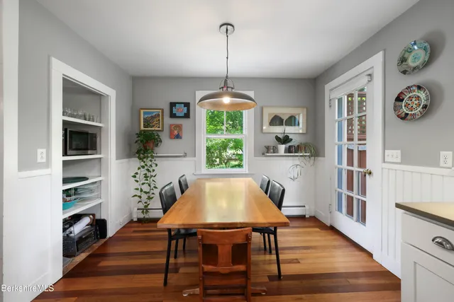 a dining room with furniture window and wooden floor