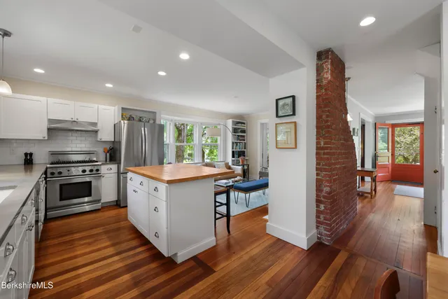 a kitchen with granite countertop a refrigerator and a stove top oven