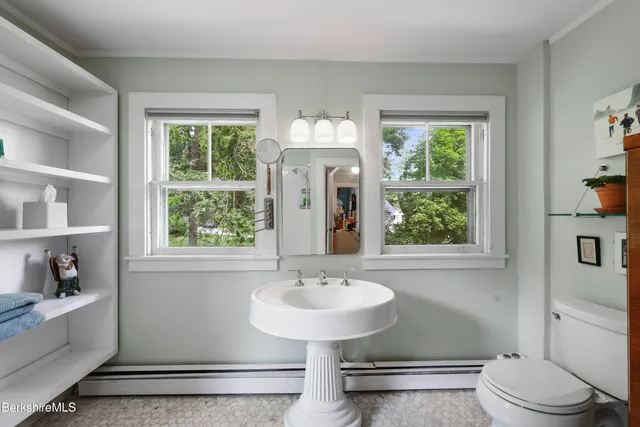 a bathroom with a sink toilet and a mirror