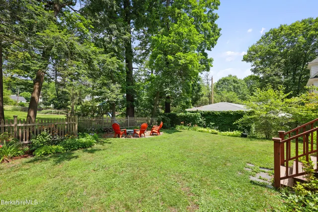 a view of a garden with a bench under an umbrella