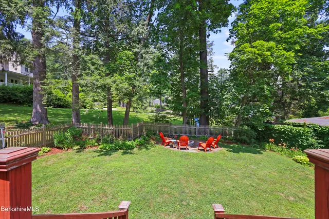 a front view of a house with swing and a tree
