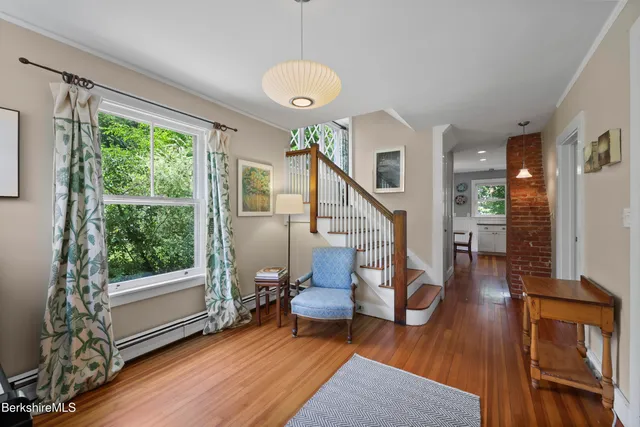 a living room with wooden floor furniture and a large window
