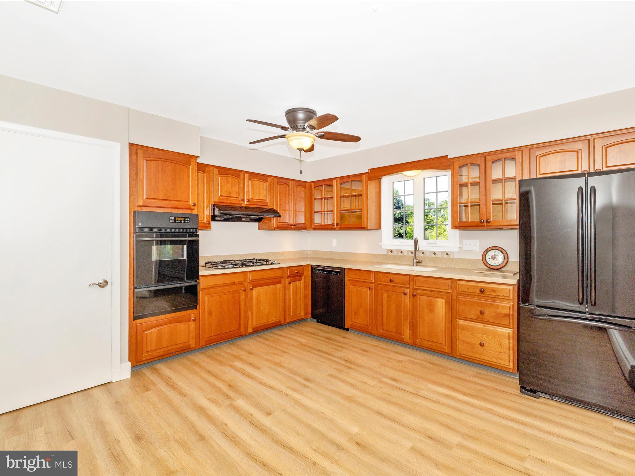 3930 Chatham Road Ellicott City, MD 21042 - Photo 17 of 51 a kitchen with stainless steel appliances granite countertop a refrigerator a sink dishwasher a stove with wooden cabinets and floor