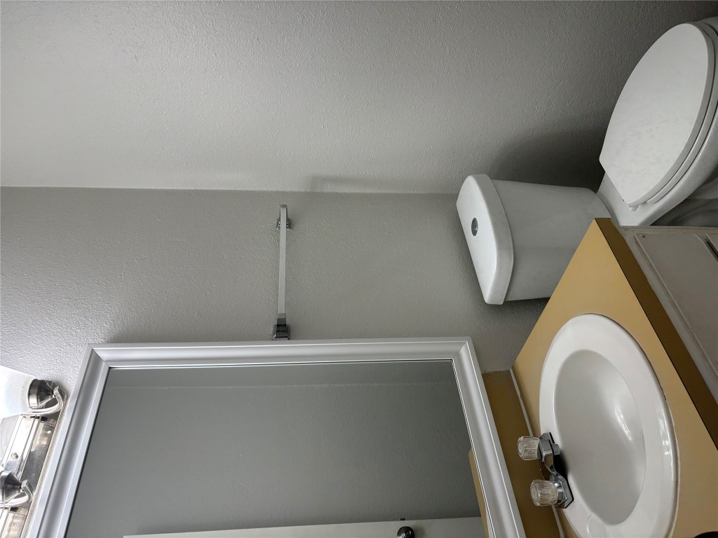 1210 Southport Drive, Unit A Austin, TX 78704 - Photo 7 of 15 a white toilet sitting next to a bathroom sink