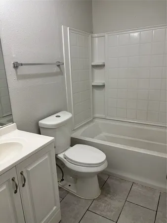 a white toilet sitting next to a bath tub