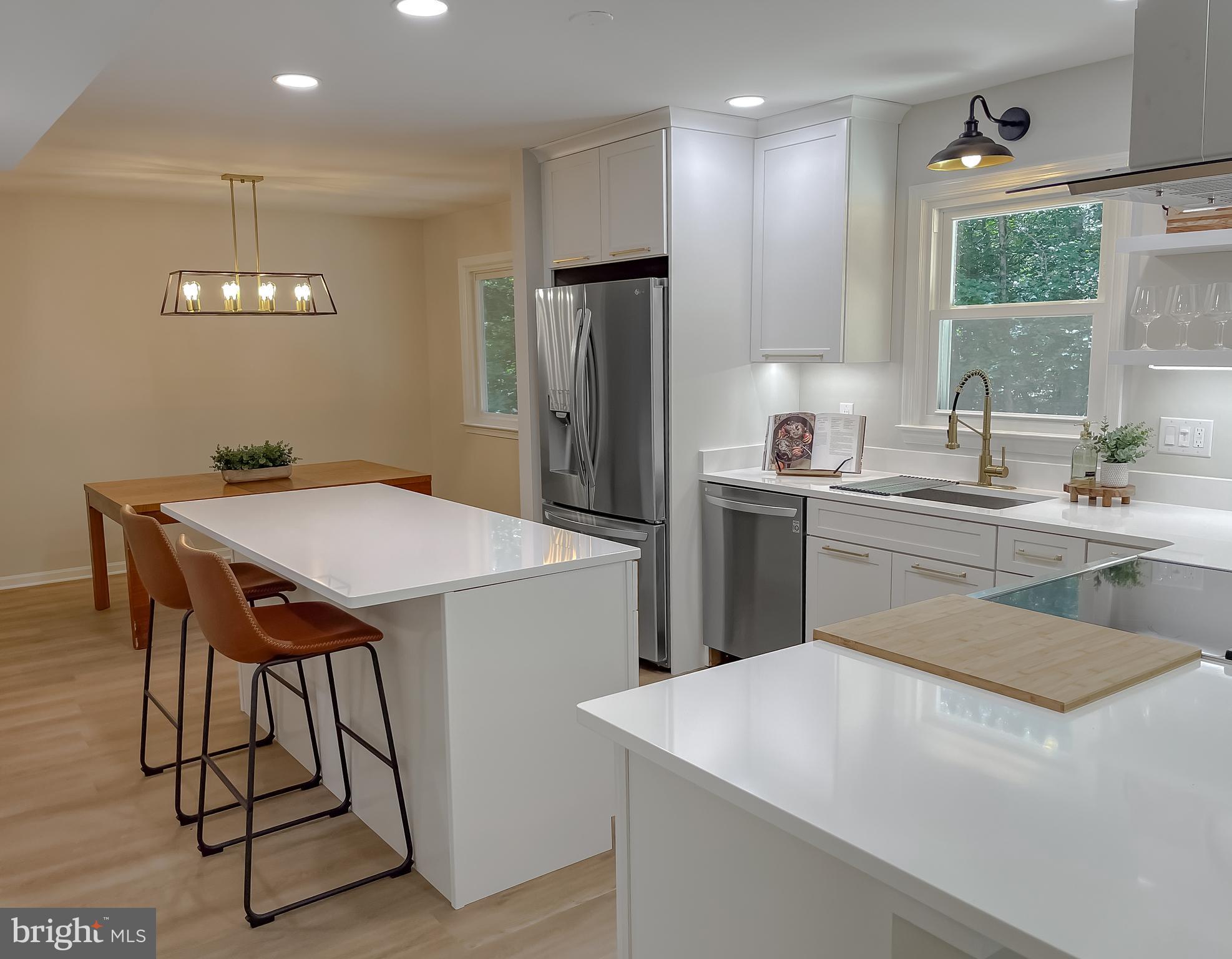 22373 Enoch Road Leonardtown, MD 20650 - Photo 16 of 74 a kitchen with stainless steel appliances kitchen island a table chairs and a sink