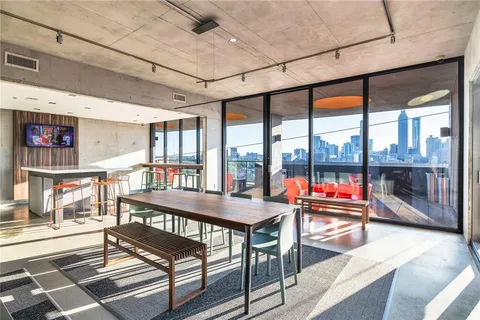 a living room with furniture a flat screen tv and floor to ceiling window