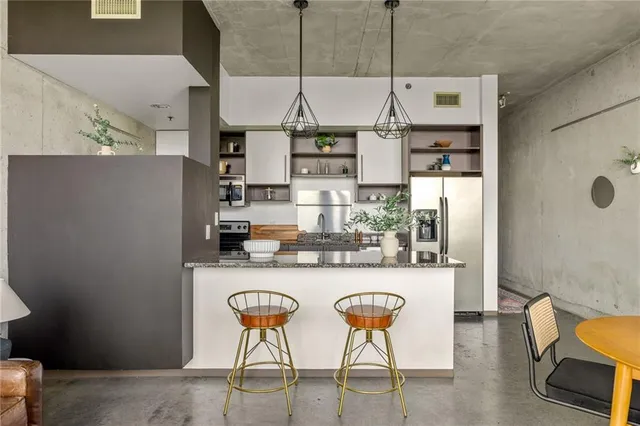 a kitchen with stainless steel appliances kitchen island granite countertop a table and chairs in it