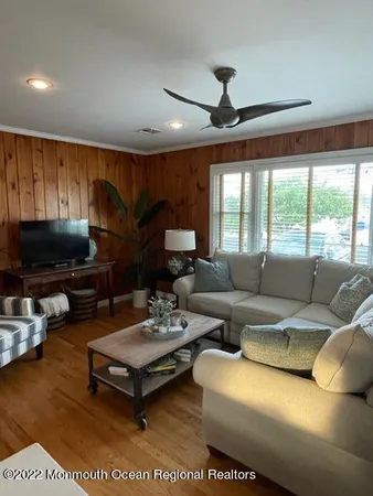 a living room with furniture a flat screen tv and a large window