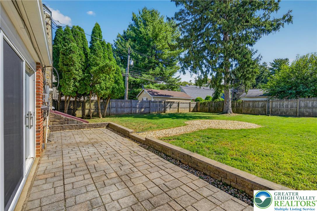 1814 Ruth Street Allentown, PA 18104 - Photo 48 of 54 A spacious paved patio overlooks the level lawn bordered by mature trees and fencing.