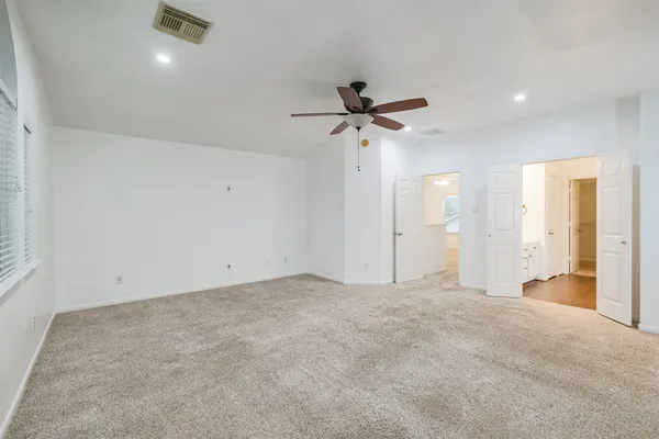 an empty room with a ceiling fan and window