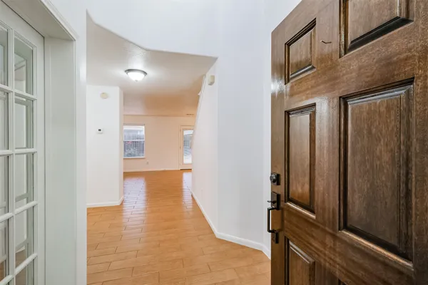 a view of a hallway with wooden floor and staircase