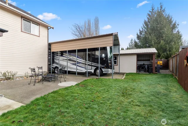 a view of a house with backyard and sitting area